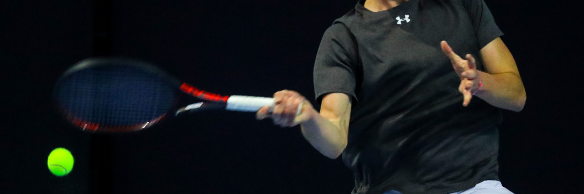 An advanced tennis player serves a tennis ball