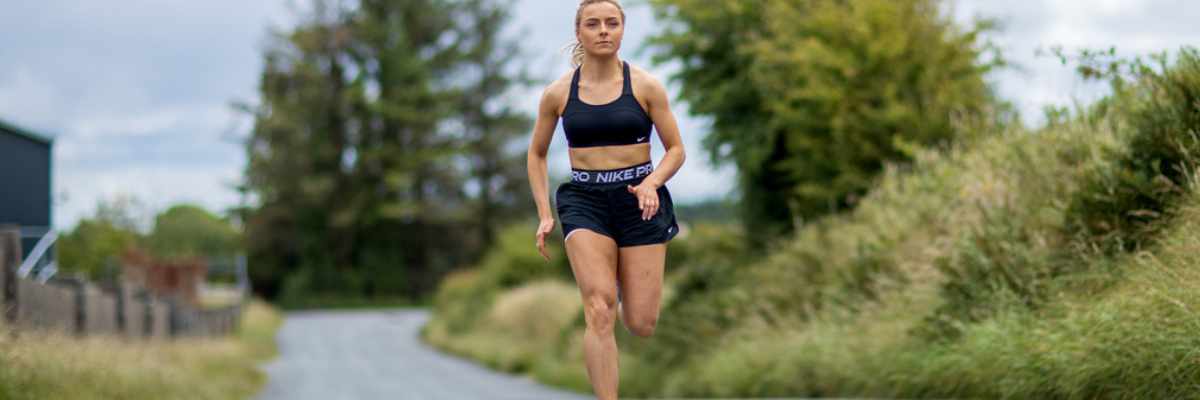 woman in sports bra running on road