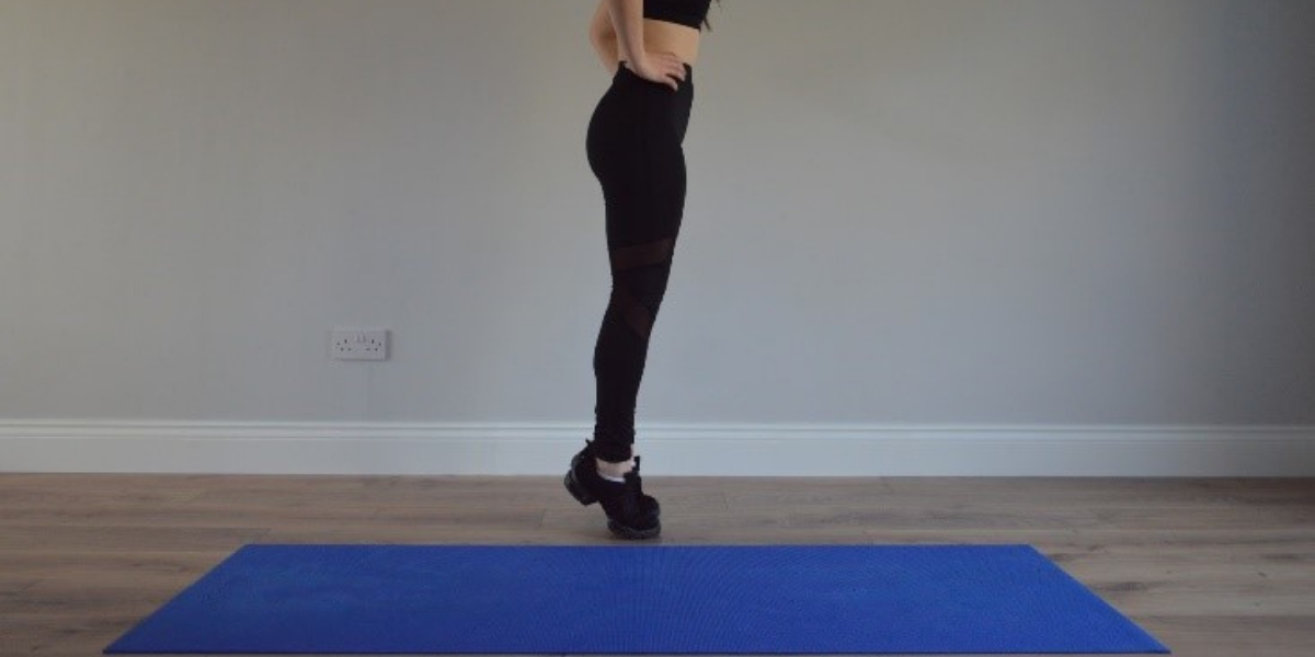 Model standing on toes working out at home
